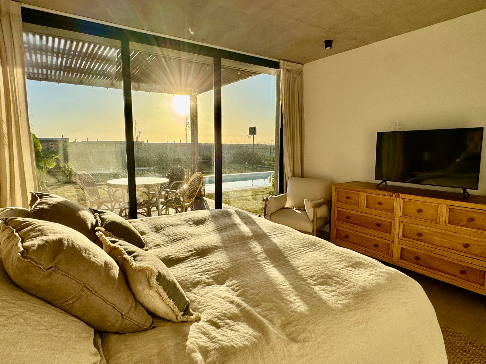 Dormitorio con ventanal al atardecer