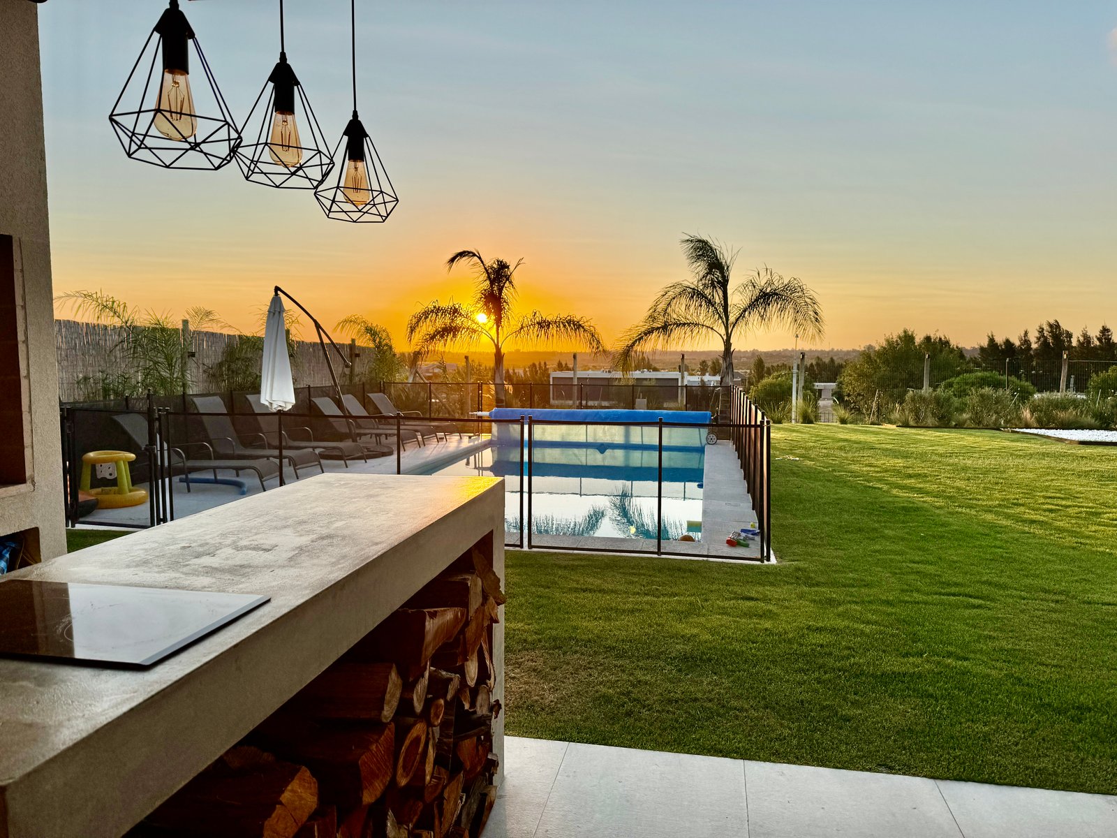 Piscina al atardecer con palmeras